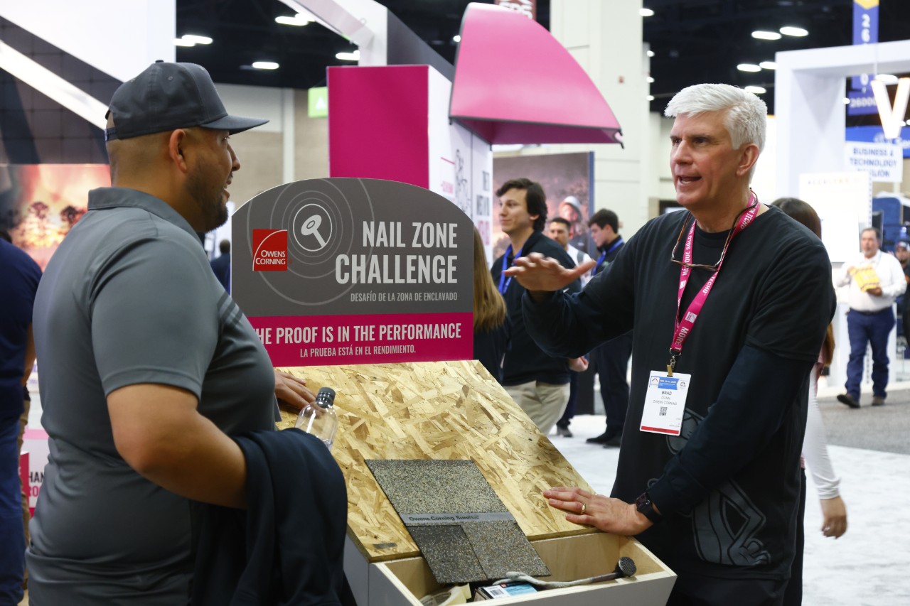 An exhibitor and an attendee discussing a product at IRE